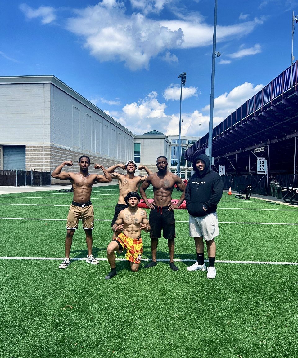 Rome Rizzo with a fitness group on indoor turf