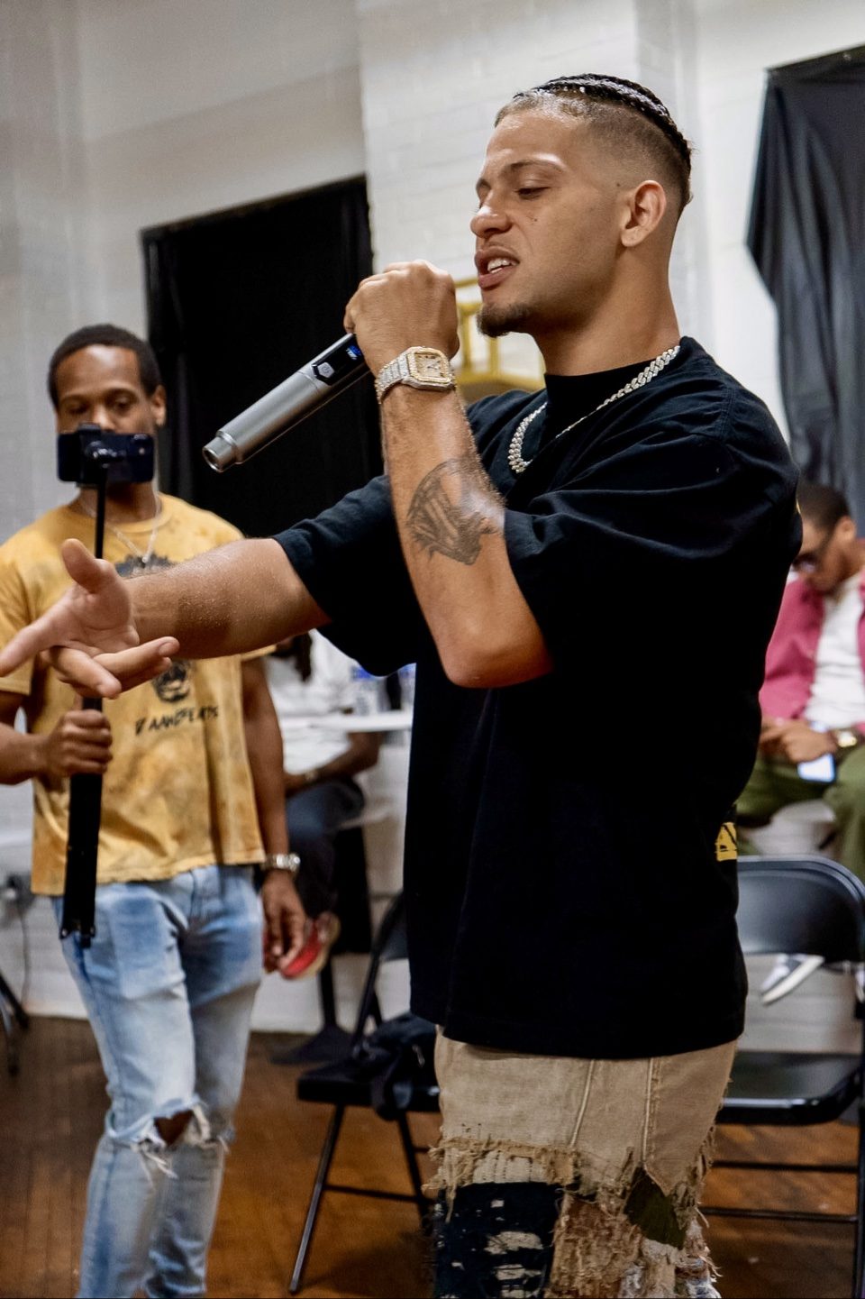 Rome Rizzo performing into a microphone with braided hair